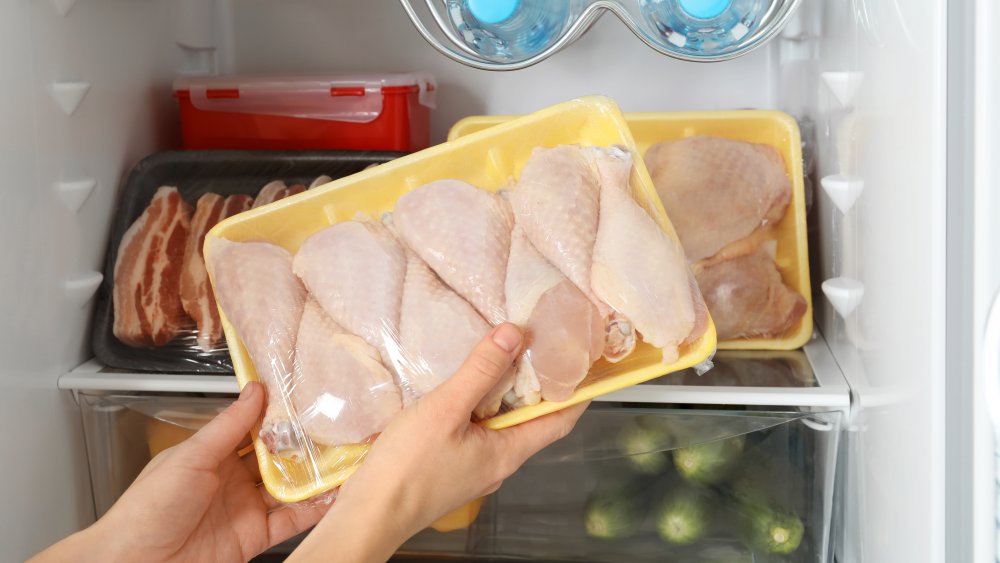 packages of raw chicken in a refrigerator