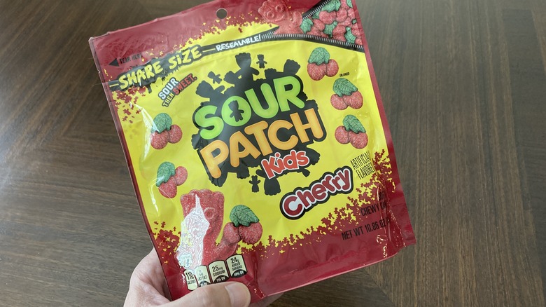 hand holding Sour Patch Kids Cherry