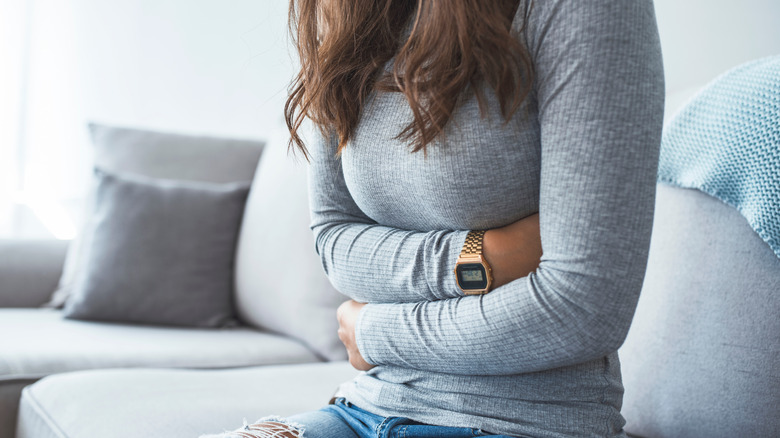 Person with stomach pain on couch