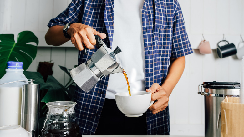 man pouring out a pot of coffee