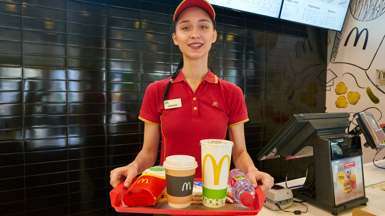 McDonald's worker carrying tray of food