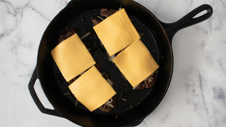 beef and cheese slices in skillet