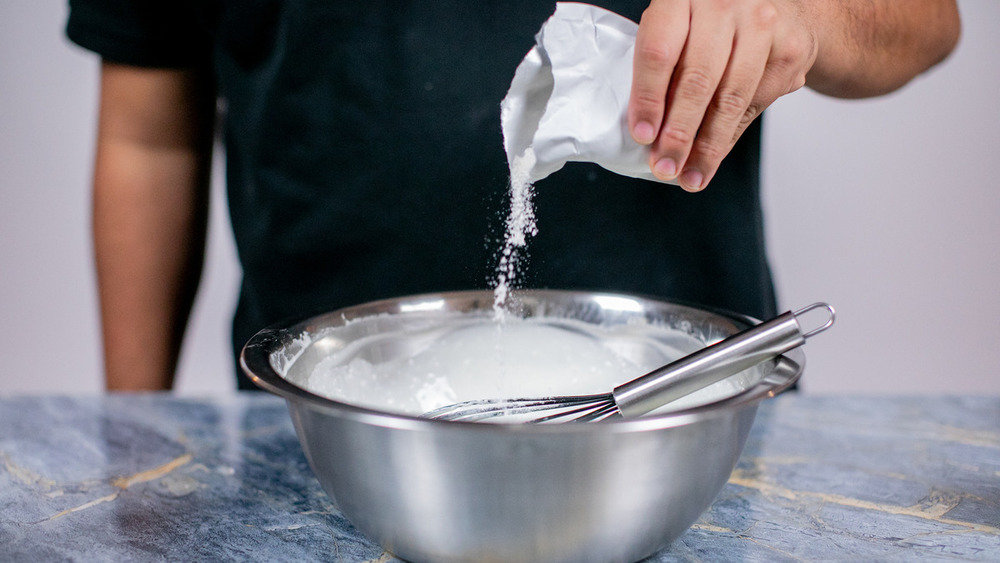 Pouring banana pudding mix into a bowl for no-bake banana pudding