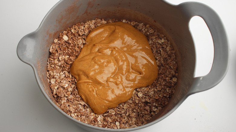 adding oat bar ingredients to bowl