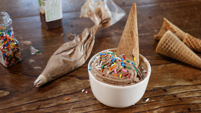 bowl of chocolate soft serve with cone and sprinkles