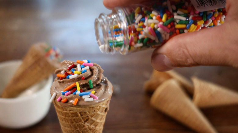 adding sprinkles to chocolate soft serve cone