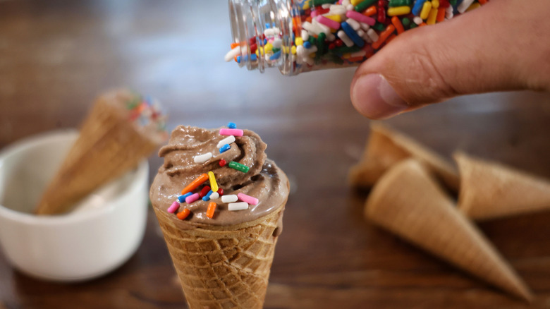 adding sprinkles to chocolate soft serve cone