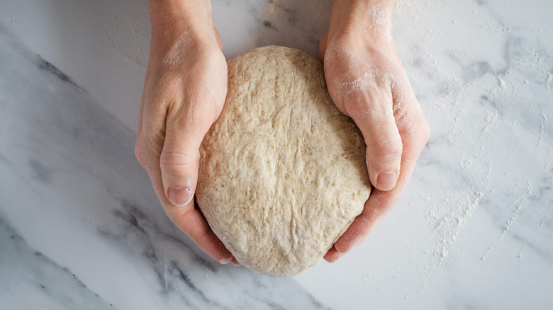 hands shaping dough loaf