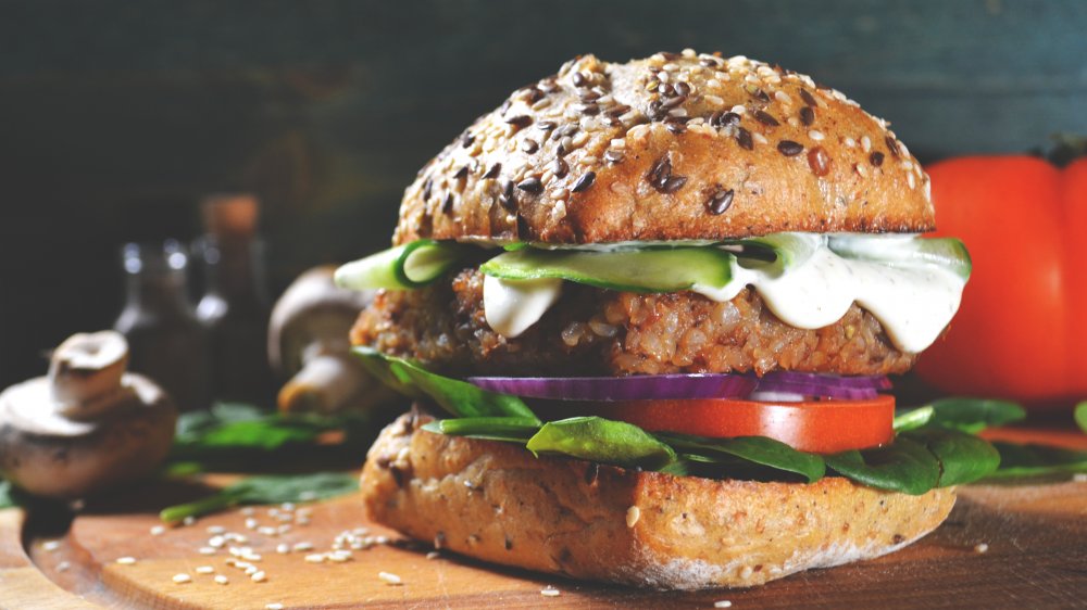 vegan burger with lettuce, tomato and onion, on whole grain bun