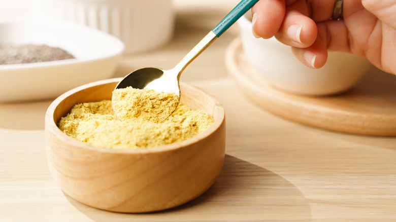 Bowl of nutritional yeast with a silver spoon