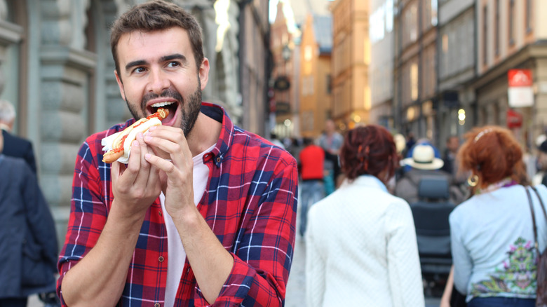 Person eating hot dog