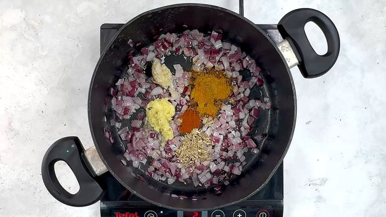 red onion and spices in pan