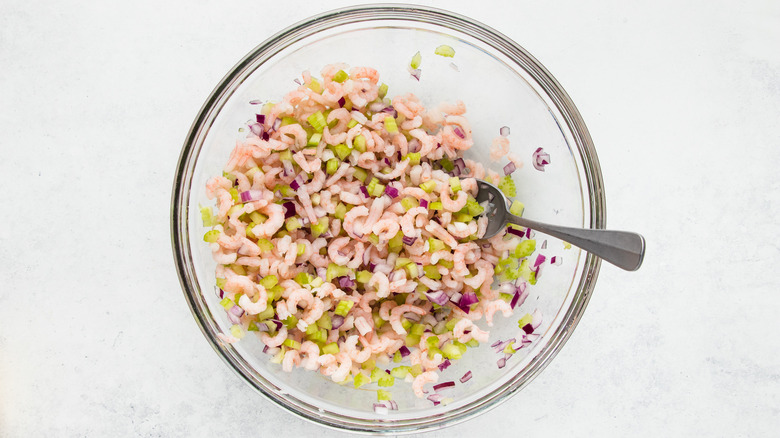 Shrimp, celery, and onion in glass mixing bowl