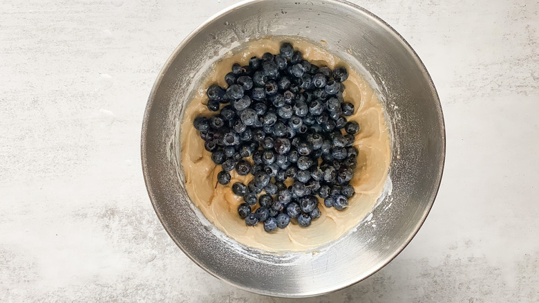 stirring blueberries into buckle batter