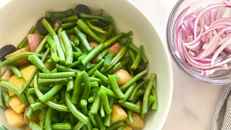 Beans and potatoes in dish with a side of onions