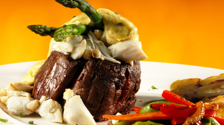 plate of steak with crab meat and asparagus