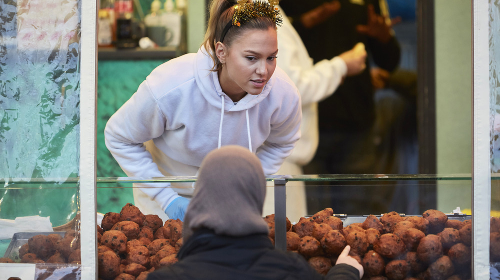 Woman selling Dutch donuts on New Year's