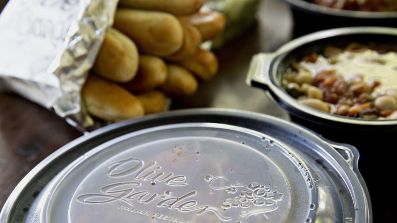 Olive Garden to-go containers with breadsticks and soup