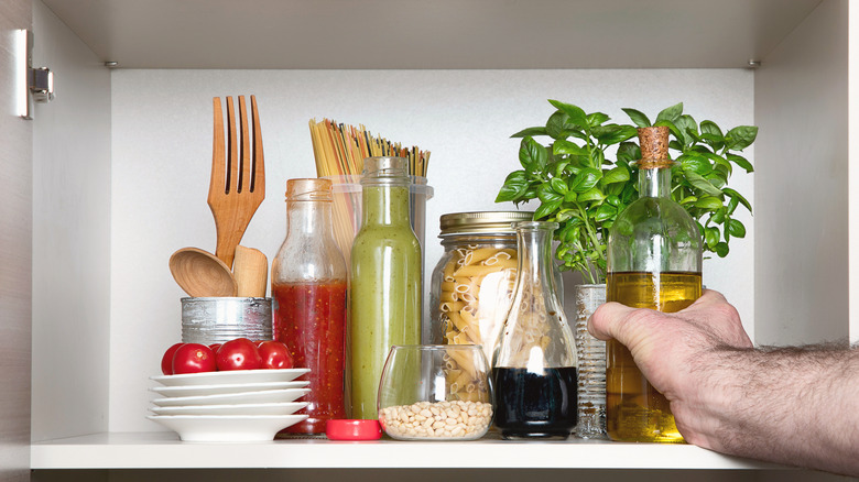 oil being put in kitchen cabinet