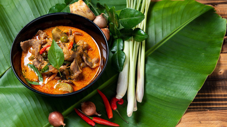 Thai red curry in bowl surrounded by ingredients