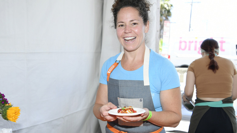 Stephanie Izard under tent holding food 