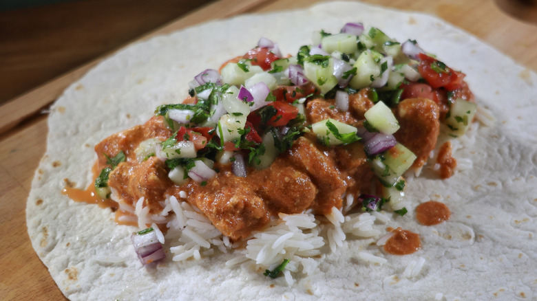 basmati rice, butter chicken, and kachumber piled on tortilla