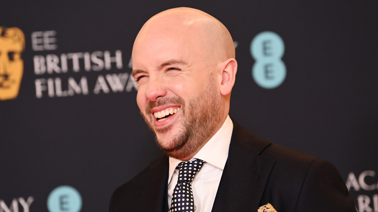 tom allen smiling for a photo at the british film awards