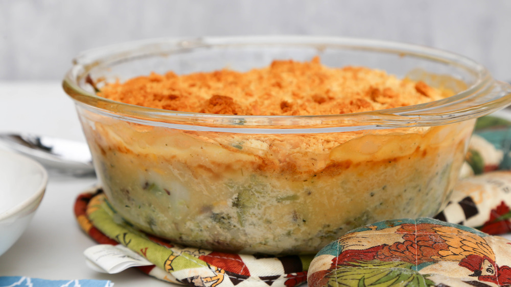 broccoli casserole topped with crackers in a glass baking dish