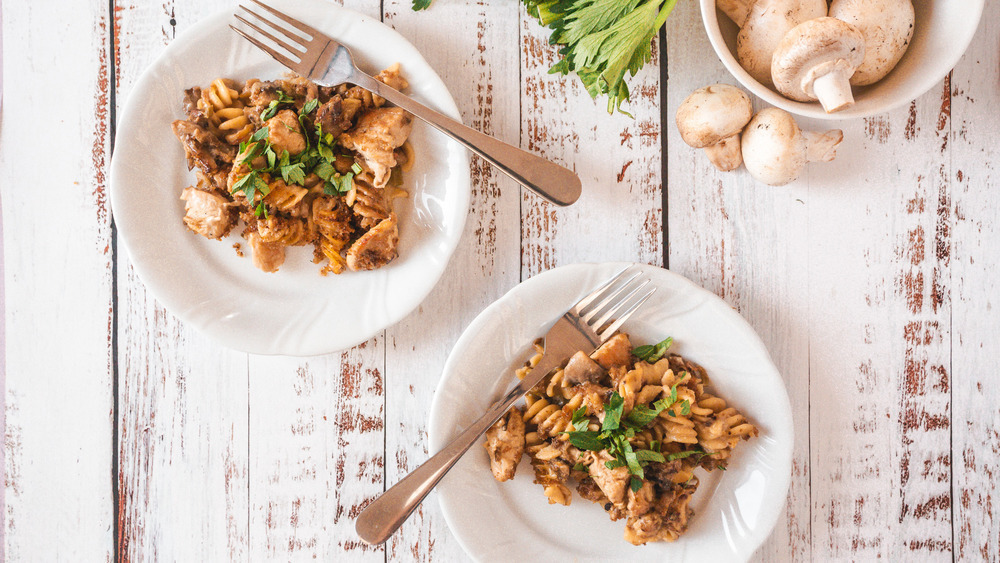 two plates of creamy chicken casserole on a white wooden table