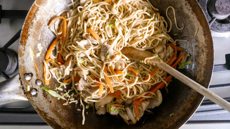 wok of noodles and chicken