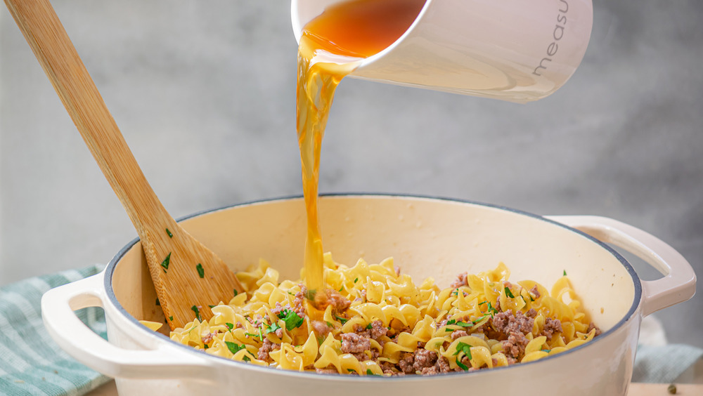 pouring beef broth in one-pot ground beef stroganoff