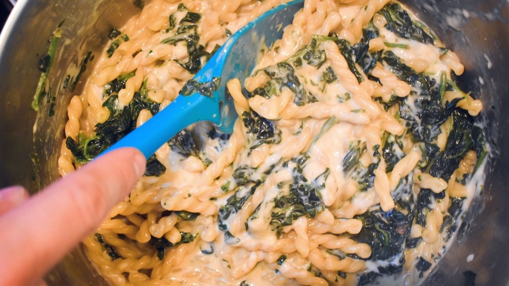 Stirring one-pot spinach and feta mac and cheese