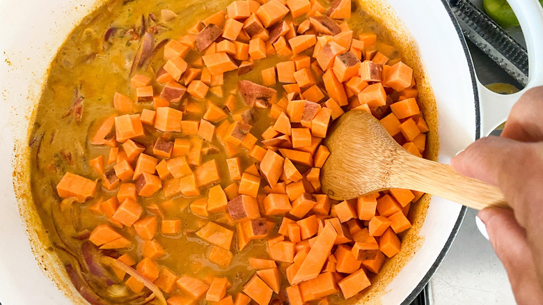 stirring sweet potatoes in pot 