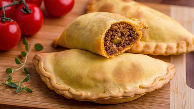 freshly baked beef empanadas cut open to show the filling