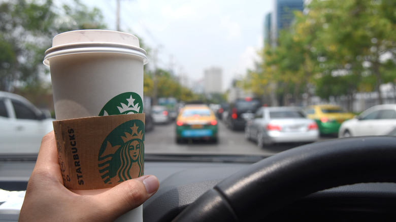 Person in car enjoying Starbucks on the go