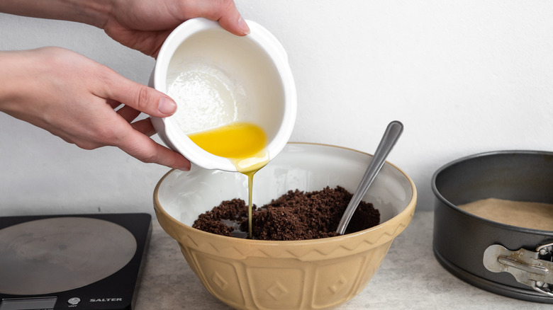 melted butter pouring into Oreo cookie crumbs