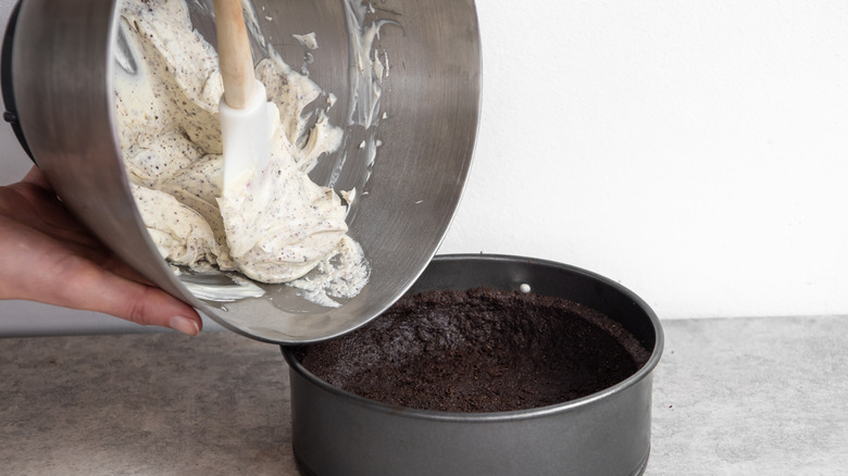 cheesecake layer pouring into Oreo pie crust