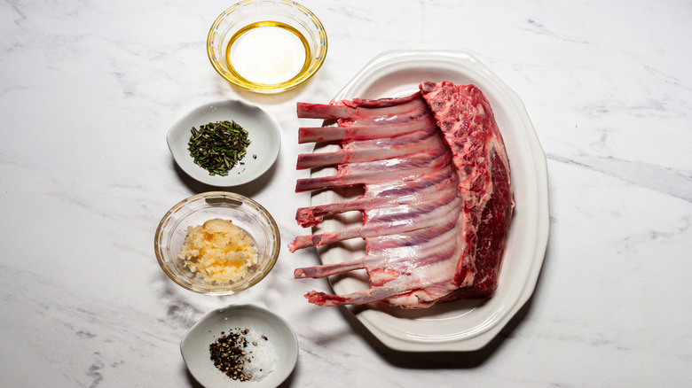 Raw lamb rack with assorted ingredients