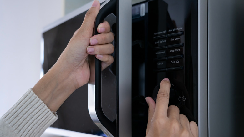 Woman putting food in microwave