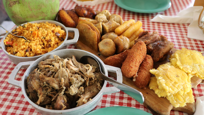 Spread of Puerto Rican dishes on checkered picnic table