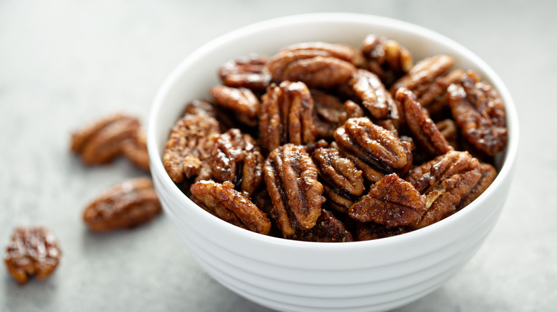 Candied pecans in a white bowl