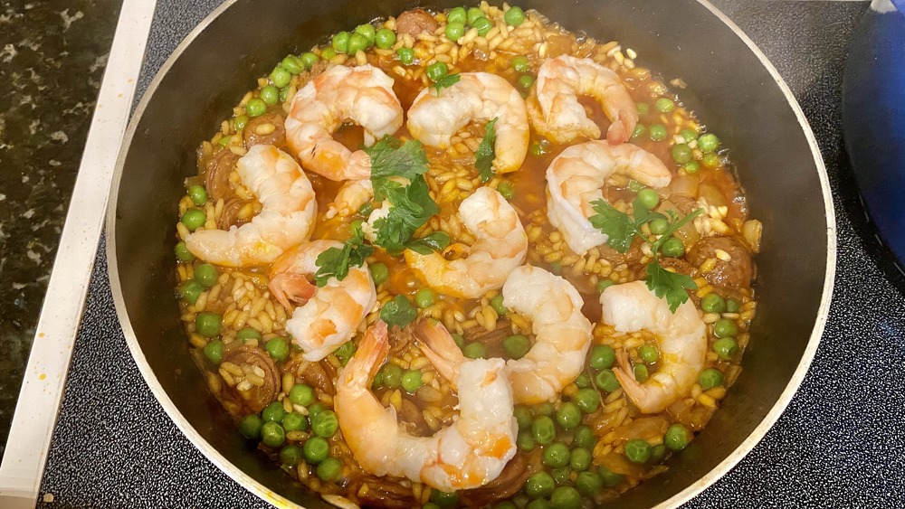 making paella with shrimp in metal pan