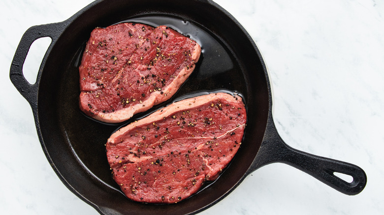 two steaks in cast-iron skillet