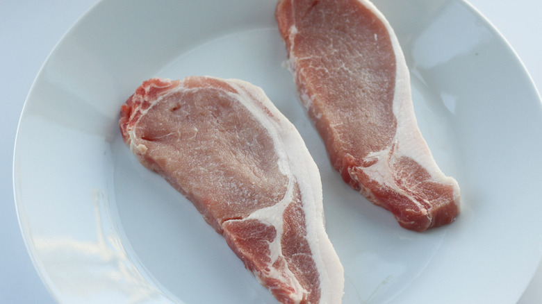 raw pork chops on plate