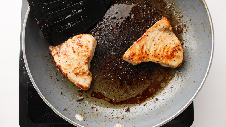 swordfish steaks cooking in a skillet