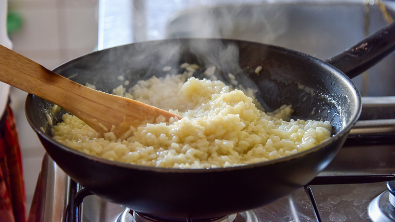 person cooking rice over stove