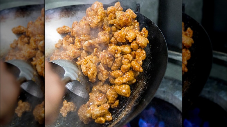 Orange chicken cooking in wok