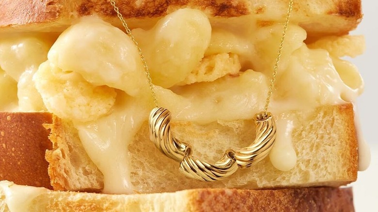 The Panera Mac and Cheese necklace next to the Mac and Cheese sandwich