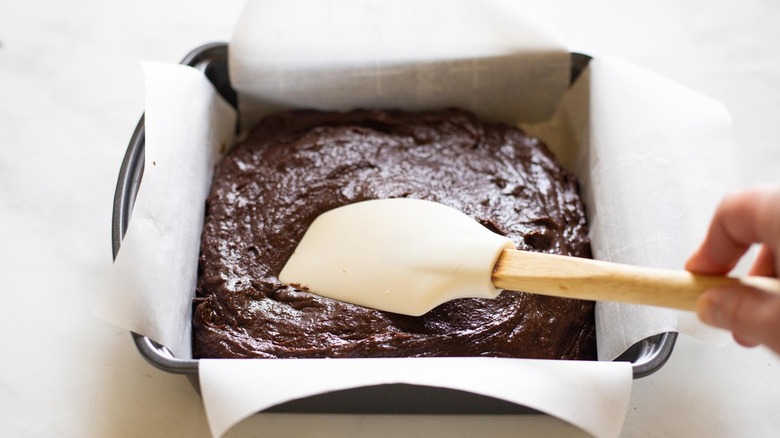 copycat Papa John's brownie batter in a baking pan with parchment paper