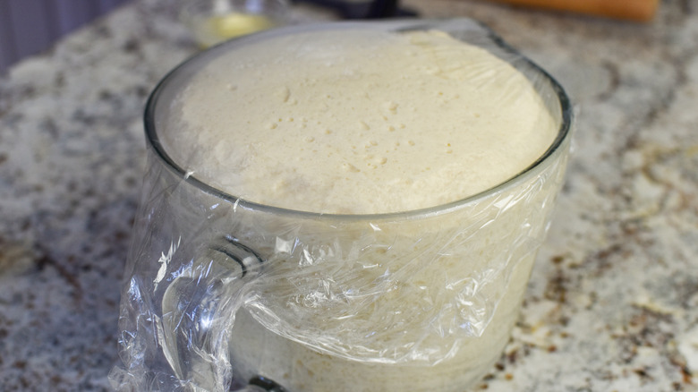 dough rising in glass bowl